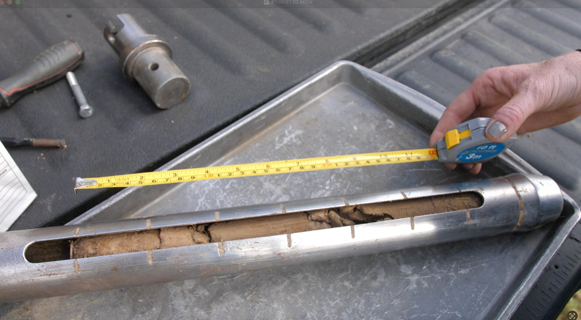 Country Roads Ag team member measuring a soil core sample in the field